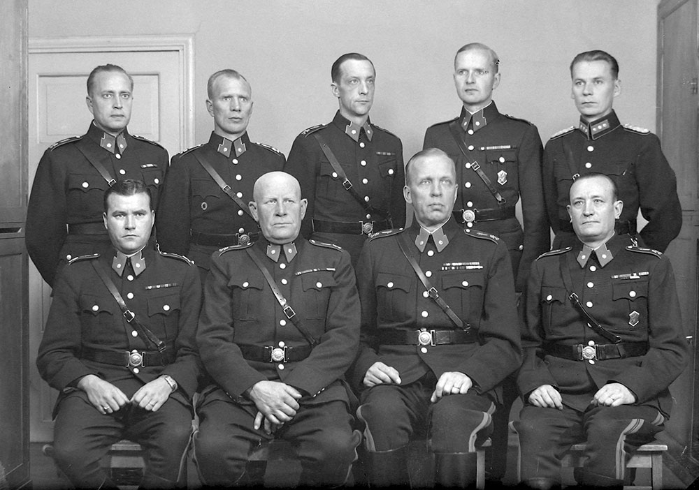 Virkapuku m1941 poisti poliisipäällystön asetakkien olkapäiltä aiemmin käytetyt hopeapunokset. Tilalle tuli miekkaleijonatunnus ja hopeanvärinen vaakunaleijona. Helsingin poliisilaitoksen vartiopiirien päälliköt vuonna 1946.