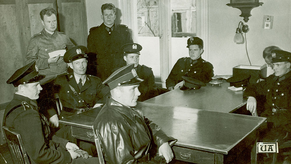 Pystykauluksinen asetakki pysyi pitkään käytössä uuden avokauluksisen takin rinnalla. Pukuvalintaan vaikuttivat paitsi henkilökohtaiset mieltymykset, myös uusien pukujen toimituksen hitaus. Turun poliisilaitoksen 1. vartiopiirin konstaapeleita 1950-luvulla.