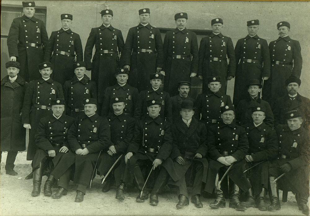 Poliisin viralliset jalkineet 1900-luvun alussa olivat polveen ulottuvat mustat nahkasaappaat. Säilyneiden valokuvien perusteella muunkinlaisia jalkineita käytettiin. Helsingin poliisilaitoksen Kallion piiri noin vuonna 1910.